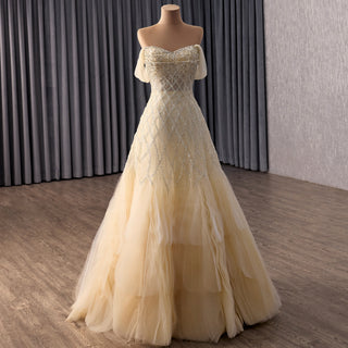 Robe de soirée luxueuse couleur champagne avec corsage perlé et jupe à volants