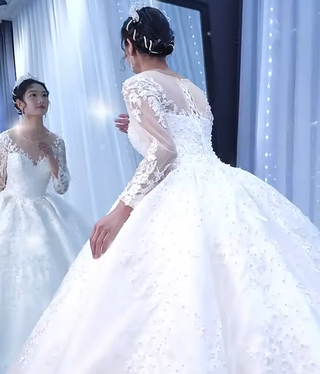 Robe de mariée bouffante en satin avec appliques en dentelle perlée et manches longues